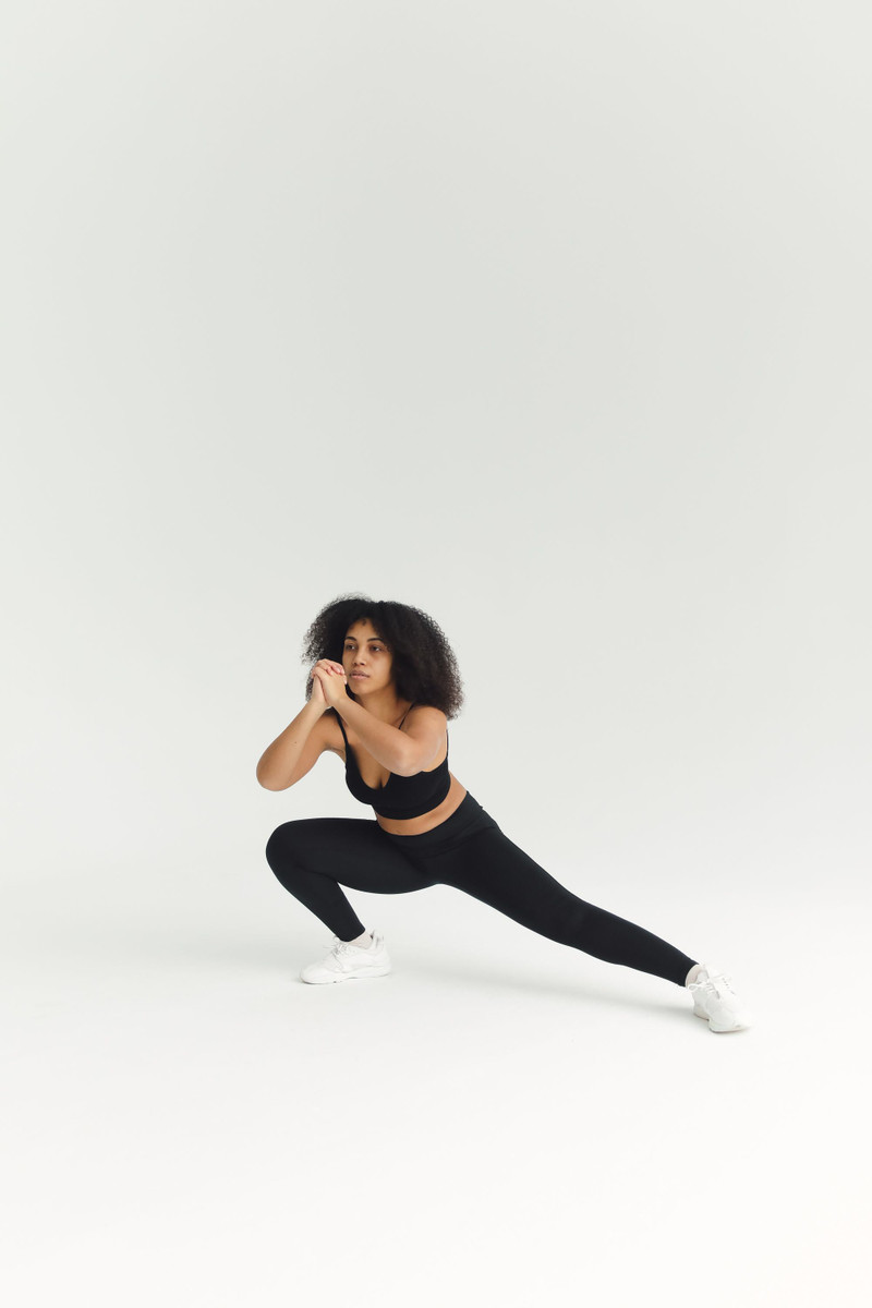 The scoop bra and leggings in a side lunge.