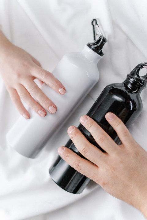 A white and a black insulated bottle on white.