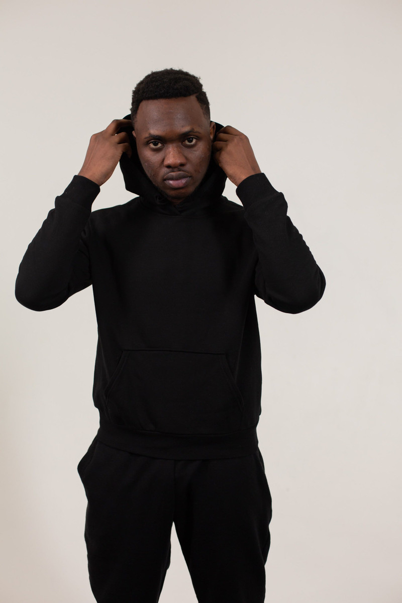A black fleece hoodie and joggers, the hood up.