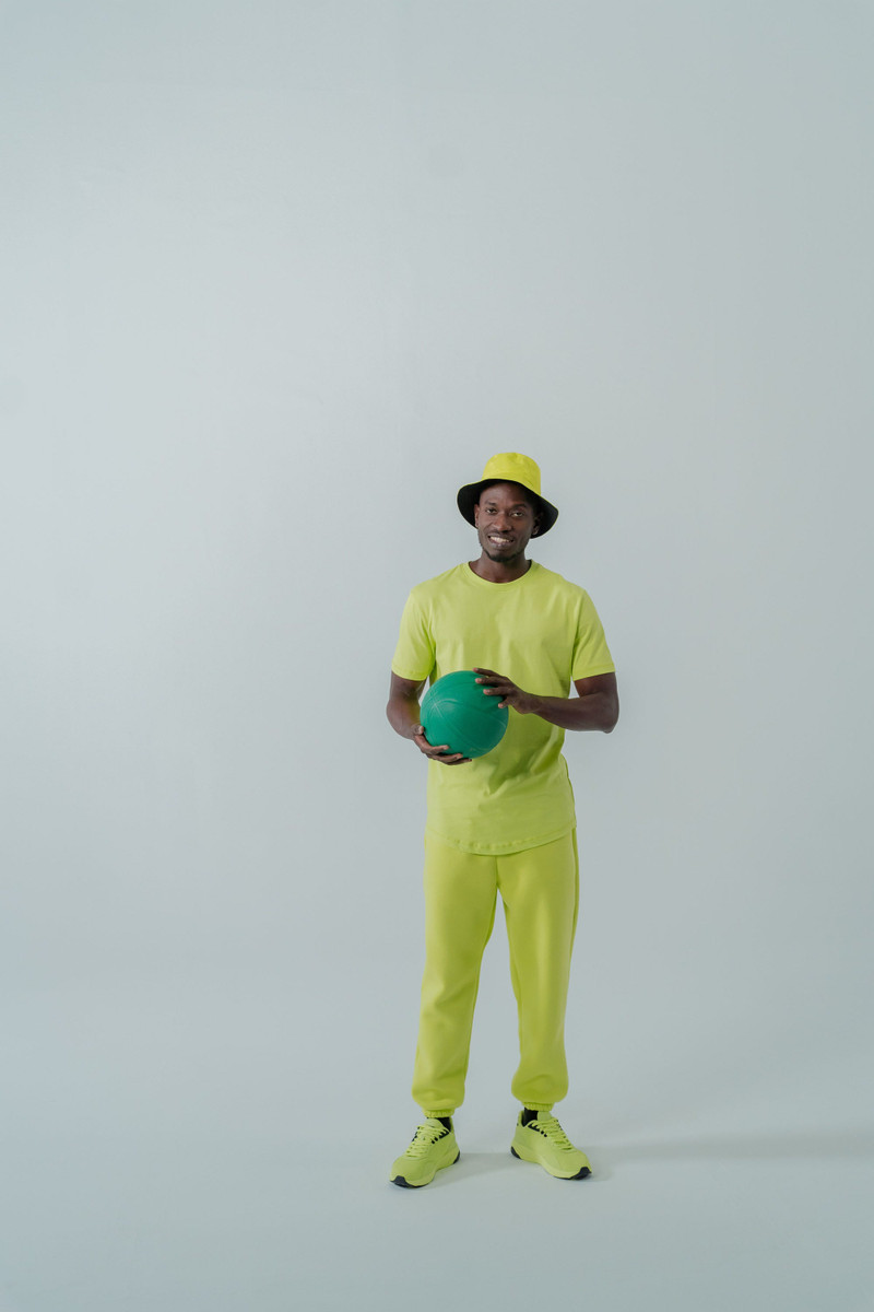 A neon lime tee and joggers with a bucket hat.